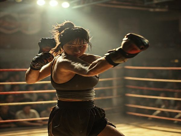 A high-definition image depicting a dynamic scene from a film set, featuring a strong female character, Rei, in an underground fighting ring. She is embodying both strength and tenderness, with a gritty yet emotional atmosphere surrounding her. The setting should evoke a sense of tension, with vivid details of the audience, fight choreography in motion, and visual hints of familial connections in the background, illustrating the duality of her identity as a mother and fighter. Soft lighting contrasts with the intensity of the fight, highlighting the feminist themes of ambition and empowerment.