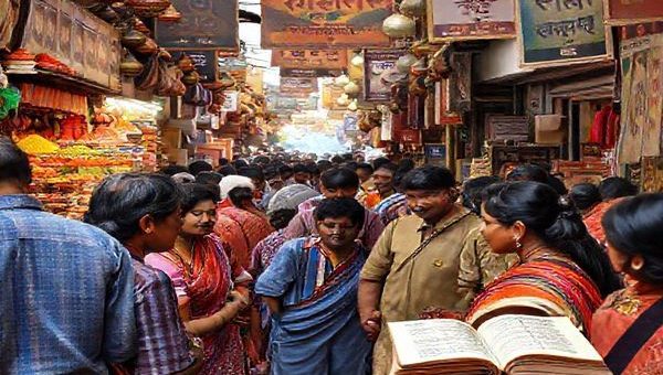A vibrant market scene in India, filled with colorful stalls showcasing traditional spices, textiles, and handicrafts. In the foreground, a diverse group of people engaging in conversation, with a backdrop of intricate Devanagari script and Bollywood posters. Flashes of life and culture interwoven with elements representing learning, like books and language apps. High definition.