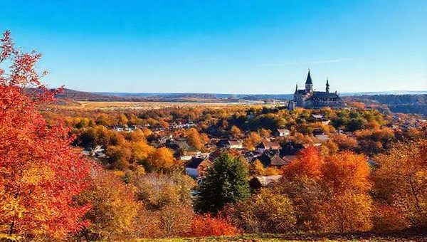 "An enchanting view of Landkreis Nordsachsen during autumn, showcasing vibrant red, orange, and gold foliage blanketing serene countryside trails, quaint villages, and majestic castles under a clear blue sky. Capture the essence of tranquility with a scattering of fallen leaves and a peaceful atmosphere, perfect for hiking and photography. High definition."