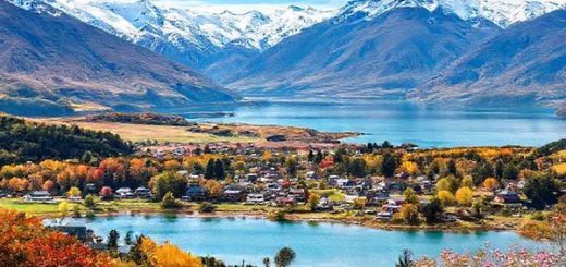 A high-definition image depicting the serene village of Otematata in New Zealand, showcasing its stunning landscapes across the four seasons: vibrant summer with sunlit lakes and outdoor activities, colorful autumn with golden and crimson foliage, a tranquil winter wonderland blanketed in snow, and a blossoming spring filled with blooming flowers. Include majestic mountains and crystal-clear lakes to capture the idyllic essence of this picturesque destination.