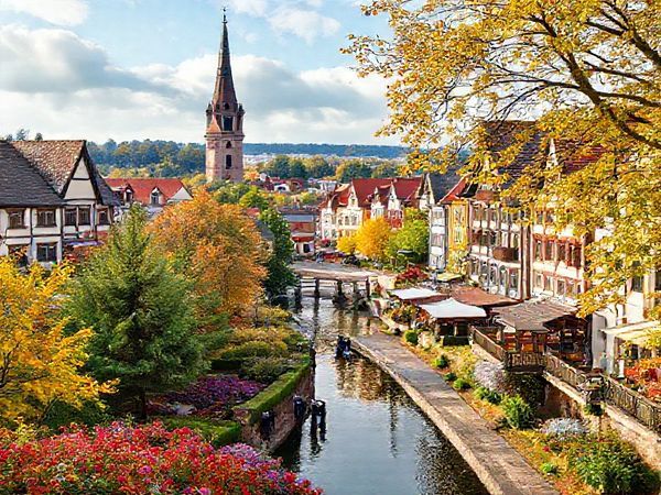 "Create a high definition image of Landkreis Zwickau, capturing its enchanting seasonal beauty: a summer scene with vibrant festivals, lush greenery, and bustling market towns; a winter wonderland with Christmas markets and snow-covered landscapes; a serene autumn tapestry of golden and crimson leaves; and a vibrant spring with blooming flowers and historical architecture. Showcase the rich cultural heritage and natural charm of this Saxon region in one cohesive image."