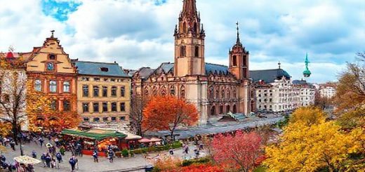 "Create a high-definition image of Leipzig during each season: a vibrant summer scene with bustling outdoor festivals and musicians, a cozy winter wonderland adorned with twinkling lights and a Christmas market, a picturesque autumn landscape with amber and golden leaves, and a blooming spring garden filled with colorful blossoms. Blend these four seasonal elements into one panoramic view of the enchanting city of Leipzig."