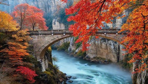 A breathtaking high-definition scene of Bastei Bridge during autumn, showcasing vibrant red, orange, and gold leaves cascading from ancient trees against stunning sandstone cliffs. The bridge arches gracefully over a swirling mist, with a tranquil Elbe River below, inviting hikers to explore the natural beauty of Saxon Switzerland National Park. The atmosphere is filled with crisp air and soft sunlight filtering through the foliage, creating a romantic and enchanting vibe.