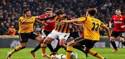 A dynamic and intense football scene capturing the thrilling clash between Wolverhampton Wanderers and Manchester United during their Premier League match at Molineux Stadium in December 2025. Show the Wolves' players in their traditional gold and black kits, fiercely pressing against Manchester United's red shirts, with a backdrop of excited fans and snow gently falling. Highlight key players like Ruben Neves and Bruno Fernandes in action, illustrating the tactical battle between teamwork and individual skill. Make the image in high definition.