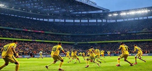 A high-definition image depicting an intense football match scene between Nantes and Lens at the Stade de la Beaujoire in December 2025. Capture Nantes in their vibrant yellow kits, exhibiting their unpredictable flair with players in action, showcasing quick transitions and creative plays. Contrast this with Lens in their tactical formation, emphasizing disciplined movements and a strong defense. The atmosphere is electric, filled with passionate fans in the stands, under a crisp winter sky, as the chess match of strategies unfolds on the pitch.