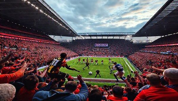 A vibrant scene depicting the intense clash between Dundee United and Rangers at Tannadice Park, December 2025. Capture the electric atmosphere of fans in colorful jerseys, players in action as they battle for possession, with a dramatic sky overhead. Include elements of a tactical chessboard subtly woven into the background, symbolizing the strategic mind games at play. High definition, showcasing the emotion and energy of this pivotal moment in Scottish football.