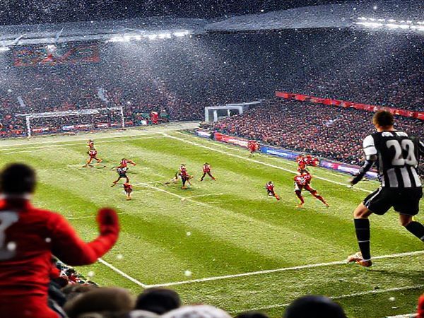 High definition image of a thrilling Scottish Premiership football match between Aberdeen and St Mirren at Pittodrie Stadium in December 2025, capturing the intensity of the game with players in action, vibrant team colors, and an electric atmosphere filled with passionate fans. Show Aberdeen in their red strips showcasing their defensive tactics against St Mirren's dynamic attacking style in their black and white kit, with a backdrop of snowy Scottish terrain.