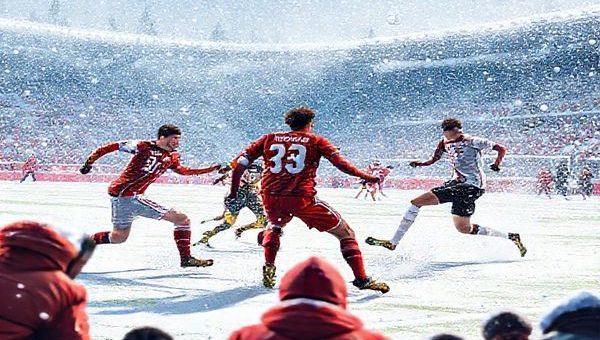 A dynamic scene depicting the high-stakes December 2025 Bundesliga match between Mainz 05 and Borussia Mönchengladbach, capturing the intensity of players in action on a snowy pitch. Show Mainz's gritty defense clashing against M'gladbach's fluid attackers, with vibrant team colors contrasting against the winter backdrop. Emphasize the strategic tension between the two teams, with onlookers in animated anticipation. Create the image in high definition.