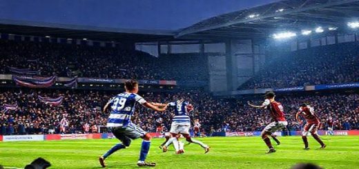 High definition image of a dramatic football match at Madejski Stadium, December 2025, featuring Reading FC in blue and white stripes clashing against Peterborough United in their iconic maroon and white kit. The stadium is buzzing with vociferous fans, waving banners, and scarves, under a crisp winter sky. Capture the essence of intense competition as players engage in a tactical battle on the pitch, with George Puscas and Jonson Clarke-Harris prominently in action. Emphasize the emotions of anticipation, resilience, and ambition in the atmosphere.