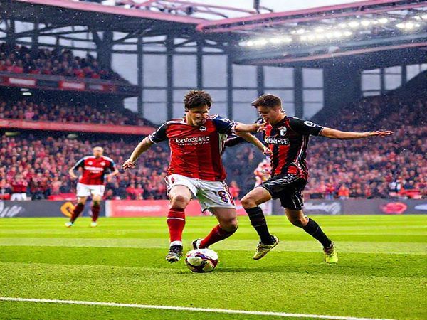 A vibrant and dynamic scene depicting the intense soccer match between Hearts and Kilmarnock at Tynecastle Park in December 2025. Capture the electrifying atmosphere with passionate fans in the stands, colorful team jerseys, and the players in action—Hearts executing a rapid attacking play against Kilmarnock’s organized defense. Emphasize the contrasting styles with Hearts' youthful vigor and Kilmarnock's disciplined approach, showcasing intricate movements and a tense moment of anticipation. Make the image in high definition.