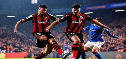 A vibrant football scene capturing a tense Premier League match between AFC Bournemouth and Everton at Vitality Stadium in December 2025. The image should show dynamic action with Bournemouth's agile players pressing high and utilizing the flanks against Everton's organized defense. Emphasize the electric atmosphere with passionate fans in the stands, team colors, and dramatic expressions on the players' faces. Make sure the image is in high definition.