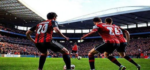 High definition image of an intense football match between Blackburn Rovers and Oxford United, set in a vibrant stadium under a clear December sky. The scene captures the moment of tension just before a dramatic play, with Blackburn's captain Darragh Lenihan leading his determined team in a robust defensive position, while Oxford's star midfielder Cameron Brannagan and striker Matty Taylor prepare to launch an agile attack. Fans in the stands are cheering passionately, showcasing team colors and banners, while the atmosphere buzzes with excitement and anticipation for this pivotal Championship encounter.