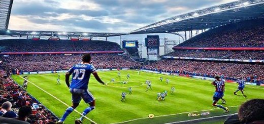 High-definition image of a vibrant football match setting at the Amex Stadium on a cold December day in 2025, showcasing Brighton & Hove Albion in their bright blue and white uniforms embodying coastal flair, contrasted with West Ham United in their claret and blue kits representing capital grit. Capture the intense action on the field, players in motion, the roar of passionate fans in the background, and a dramatic sky setting the stage for this epic Premier League clash.