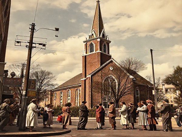 "High-definition image of a 1940s street scene featuring a church with a tall steeple, set against a backdrop of post-war optimism and uncertainty. Capture a diverse group of people engaging in conversation outside the church, reflecting hope and curiosity about the future of religion. Incorporate elements of early technology, like radio antennas and film posters of clergy in movies, to symbolize the church's evolving role in a changing world."