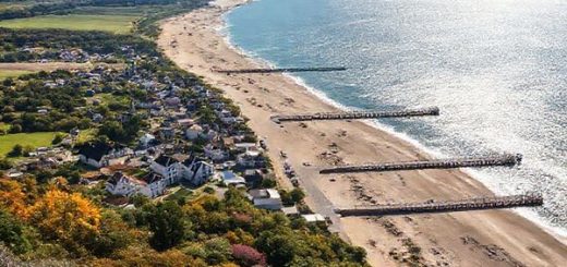 A breathtaking view of Usedom Island showcasing its diverse seasonal beauty: in summer, vibrant beachgoers enjoying sunny shores; in autumn, golden foliage along scenic trails; in winter, serene snow-covered landscapes; and in spring, blooming flowers amid lush greenery. The historic seaside resorts with distinct architecture and long piers should be visible, set against the backdrop of the sparkling Baltic Sea. Capture this charm in high definition.